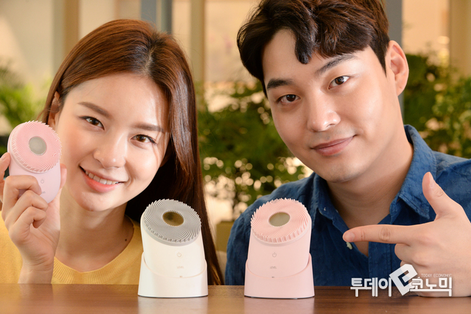 모델들이 기존 '코튼 화이트' 색상과 함께 새롭게 선보인 '블라썸 핑크' 색상의 LG 프라엘 초음파 클렌저(모델명: BCN1)를 소개하고 있다.(사진=LG전자)