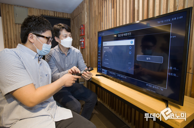 삼성전자 상품전략팀 직원(오른쪽)이 서울 관악구에 위치한 실로암 시각장애인 복지관에서 한 시각 장애인에게 삼성전자 스마트TV의 접근성 기능에 관해 설명하고 있다. (사진=삼성전자)