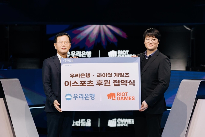 지난 30일 종로구 롤파크 이스포츠 경기장에서 진행된 이스포츠 후원 협약식에서 조병규 우리은행장(왼쪽)과 조혁진 라이엇 게임즈 코리아 대표가 기념사진을 촬영하고 있다. (사진=우리은행)