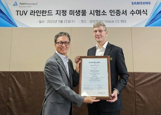 삼성전자 김학상 글로벌CS센터장(왼쪽)과 TUV 라인란드 한국지사 프랭크 마이클 주트너 대표가 인증서를 들고 기념 촬영을 하고 있다. 사진=삼성전자