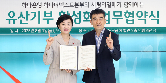 하나은행은 지난 1일 오후 서울시 중구 소재 사랑의열매 별관에서 사랑의열매와 유산 기부 활성화를 위한 업무협약을 체결했다. 이은정 하나은행 하나더넥스트본부장(사진 왼쪽)이 황인식 사랑의열매 사무총장(사진 오른쪽)과 업무협약서를 들고 기념 촬영을 하고 있다. 사진=하나은행
