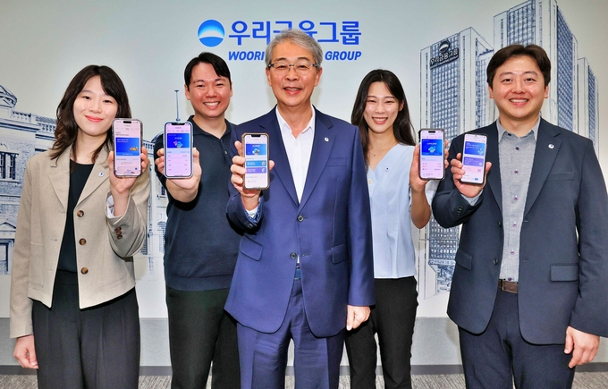 우리금융그룹 임종룡 회장(가운데)이 지난 6일 유니버설뱅킹 신규 가입자 100만명 돌파를 기념해 직원들과 사진을 촬영하고 있다. 사진=우리금융그룹