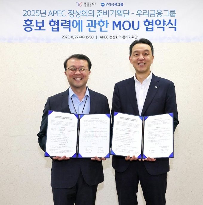 이정섭 우리금융지주 브랜드부문장(오른쪽)이 지난 27일 김지준 아시아태평양경제협력체(APEC) 정상회의 준비기획단 기획실장과 홍보 협력 업무협약을 체결한 뒤 기념사진을 촬영하고 있다. 사진=우리금융그룹