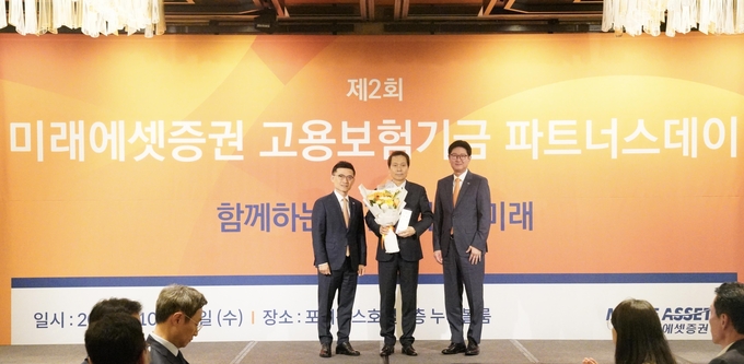 22일 미래에셋증권 고용보험기금 파트너스데이 행사가 열린 서울 광화문 포시즌스 호텔에서 고용보험기금 우수 위탁 운용사 대상을 수상한 한국투자신탁운용 배재규 대표이사(가운데)와 미래에셋증권 김미섭 부회장(왼쪽), 미래에셋증권 법인솔루션부문 구종회 부문대표(오른쪽)가 기념촬영을 하고 있다. 사진=미래에셋증권